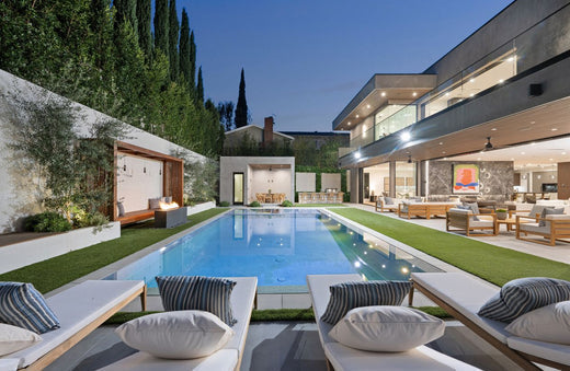 Luxury backyard with illuminated pool at dusk