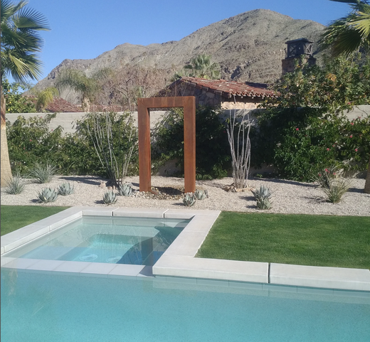 Modern rain curtain fountain near pool with desert landscape