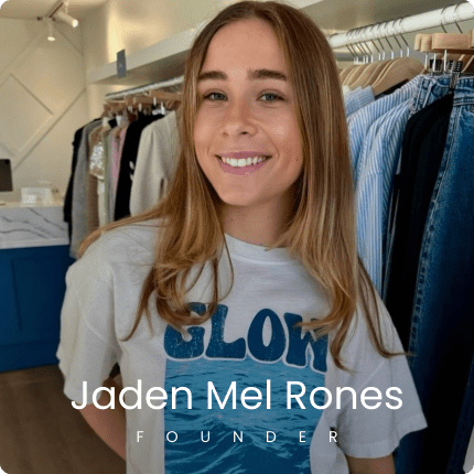 Smiling woman in boutique with "Glow" t-shirt, Jaden Mel Rones, founder