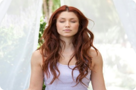 Woman meditating peacefully with eyes closed outdoors