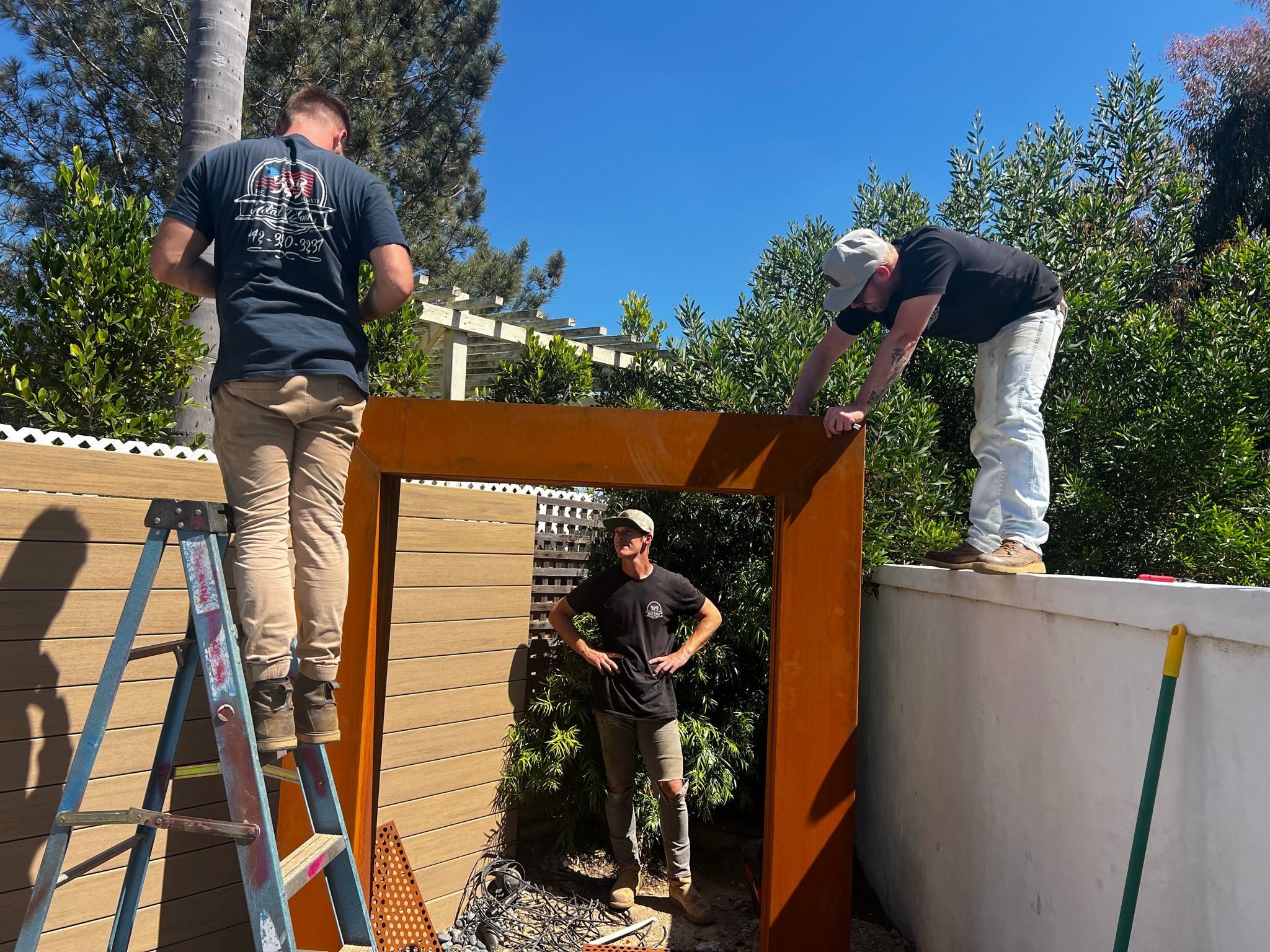  Workers installing corten steel water feature